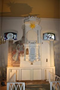 Pulpit altar of the Tauche village church during the first stage of restoration, showing partially uncovered historic wall painting and original architectural elements
