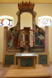 Fully restored pulpit altar in the church of Tauche, Brandenburg, shown without liturgical textiles, highlighting the restored architectural and painted structure