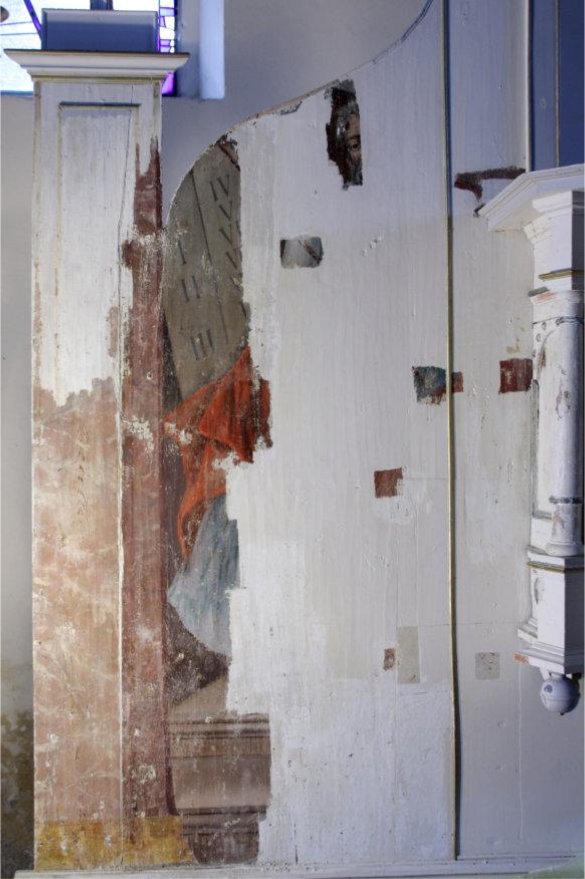 Partial uncovering of the altar wall painting depicting Moses with the Tablets of the Law during early restoration, revealing original paint beneath later overpaint